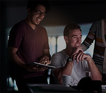 Group of people, smiling, looking at a computer screen.